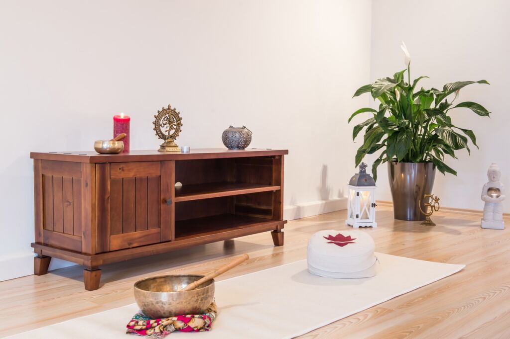 Ein schönes Ambietene bei Dein Yogaraum Schorndorf. Yogamatte und Klangschale vor Regal.
