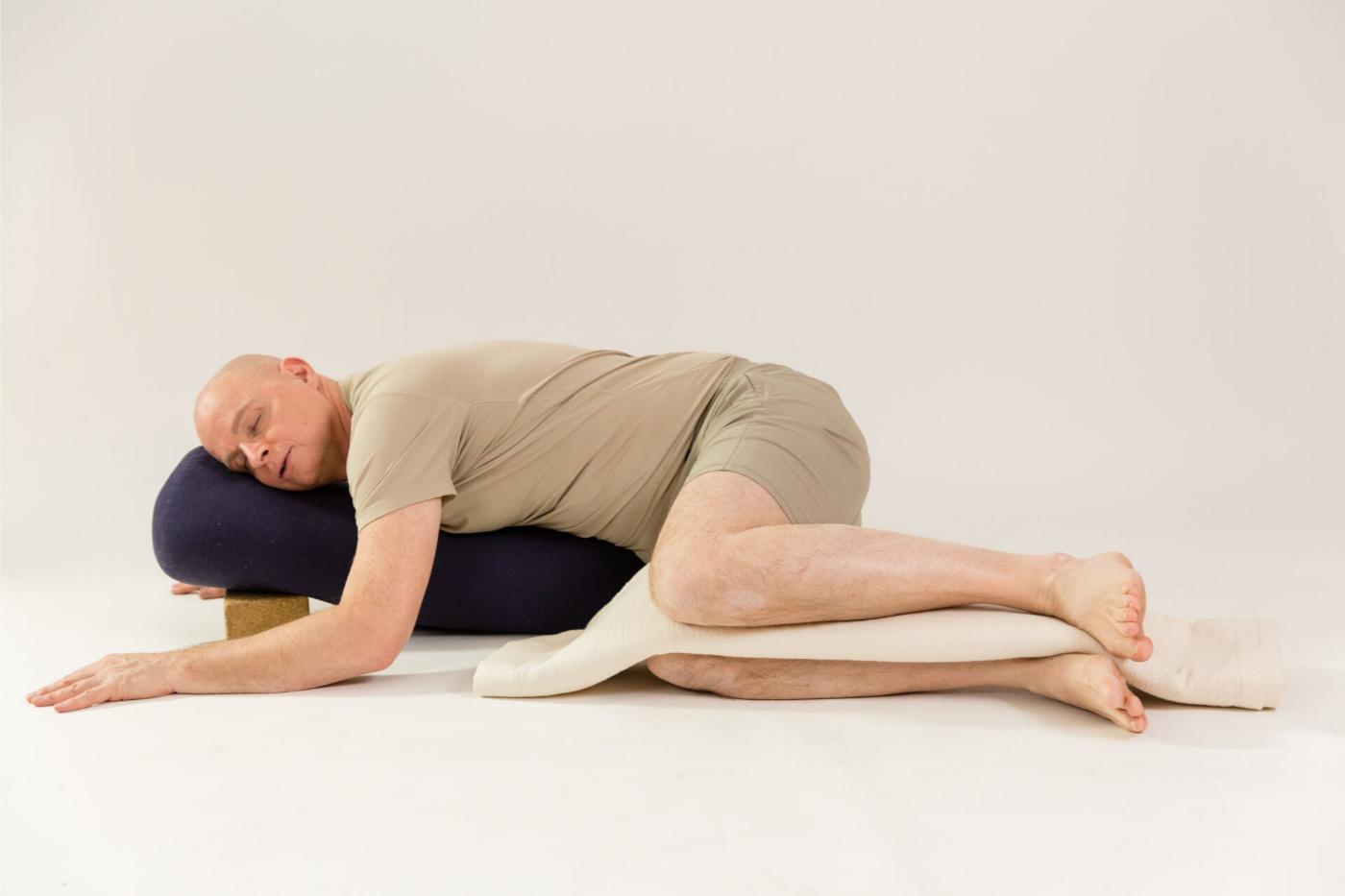 René Hug in Yin Yoga Haltung, unterstützt mit Bolstern zur sanften Ansprache der Faszien René Hug in Yin Yoga Haltung, unterstützt mit Bolstern